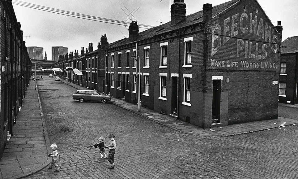 Photo from the 1960s by Nick Hedges, of a housing complex with three small children in the foreground.