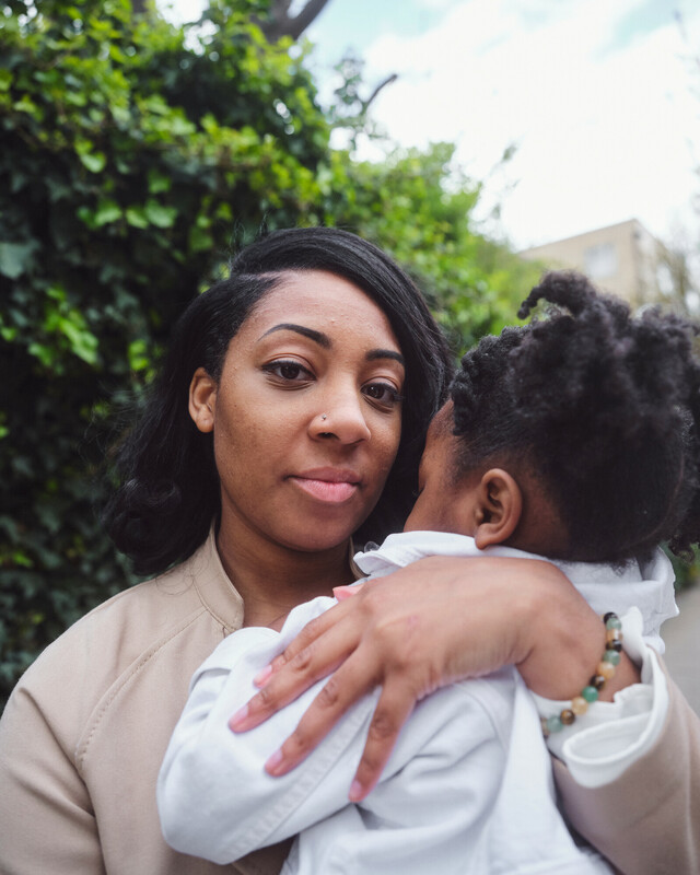 Woman looking at the camera while holding her baby