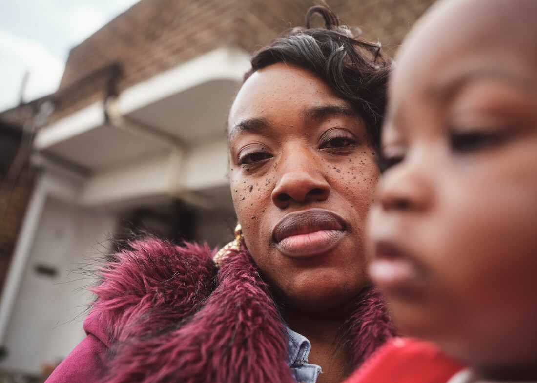 Mother looking at camera with her baby in the foreground.