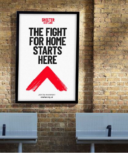 Image of a Shelter poster on a train station wall, saying 'The fight for home starts here'